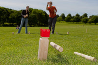 Viking kubb game being played outside by two people.