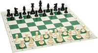 Black and white Staunton chess pieces on green chess board.