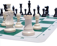Zoomed in picture of Staunton chess pieces on green chess board.