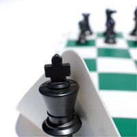 King chess piece lifting the corner of silicone chess board.