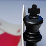 Zoomed in picture of king lifting up corner of silicone chess board.