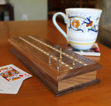 6 metal pegs played on cribbage board on table.