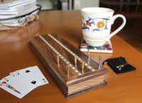 6 cribbage pegs on cribbage board on table.