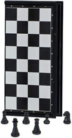 Magnetic chess board folded with a few black chess pieces sitting in front.