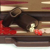 Zoomed in picture of the briefcase opened with dice and dice cups in the center with chips on the side.