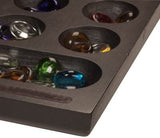 Zoomed in corner of Mancala with the glass stones filling the holes on the board.